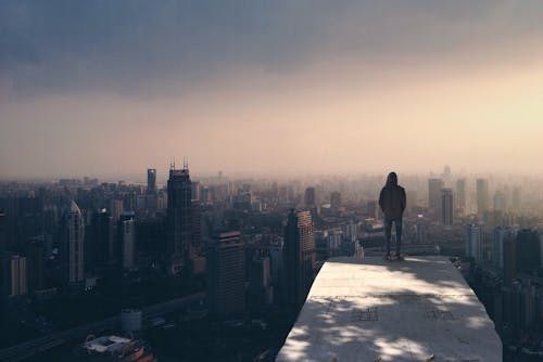 "Person standing on hilltop looking toward horizon, symbolizing hope and navigation through global polycrisis"